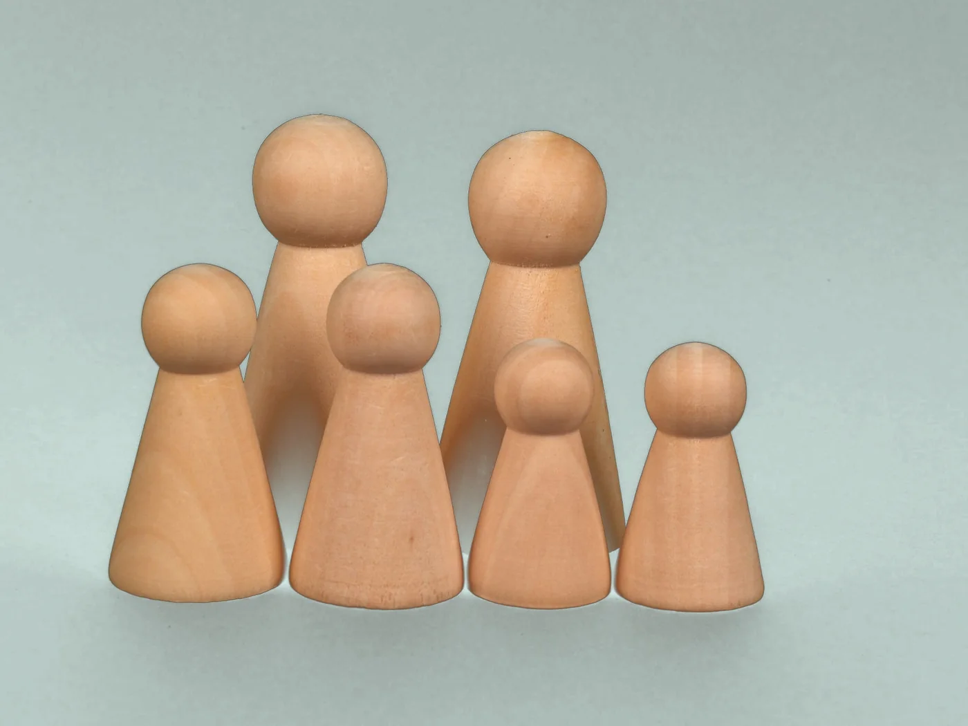 Des figurines en bois disposées comme dans une constellation familiale
