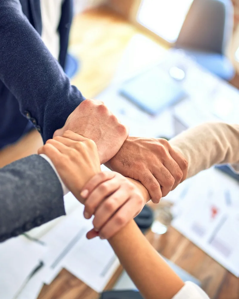 Les mains d'une &eacute;quipe r&eacute;unies au-dessus de la table